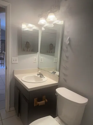 a bathroom with a sink toilet and mirror