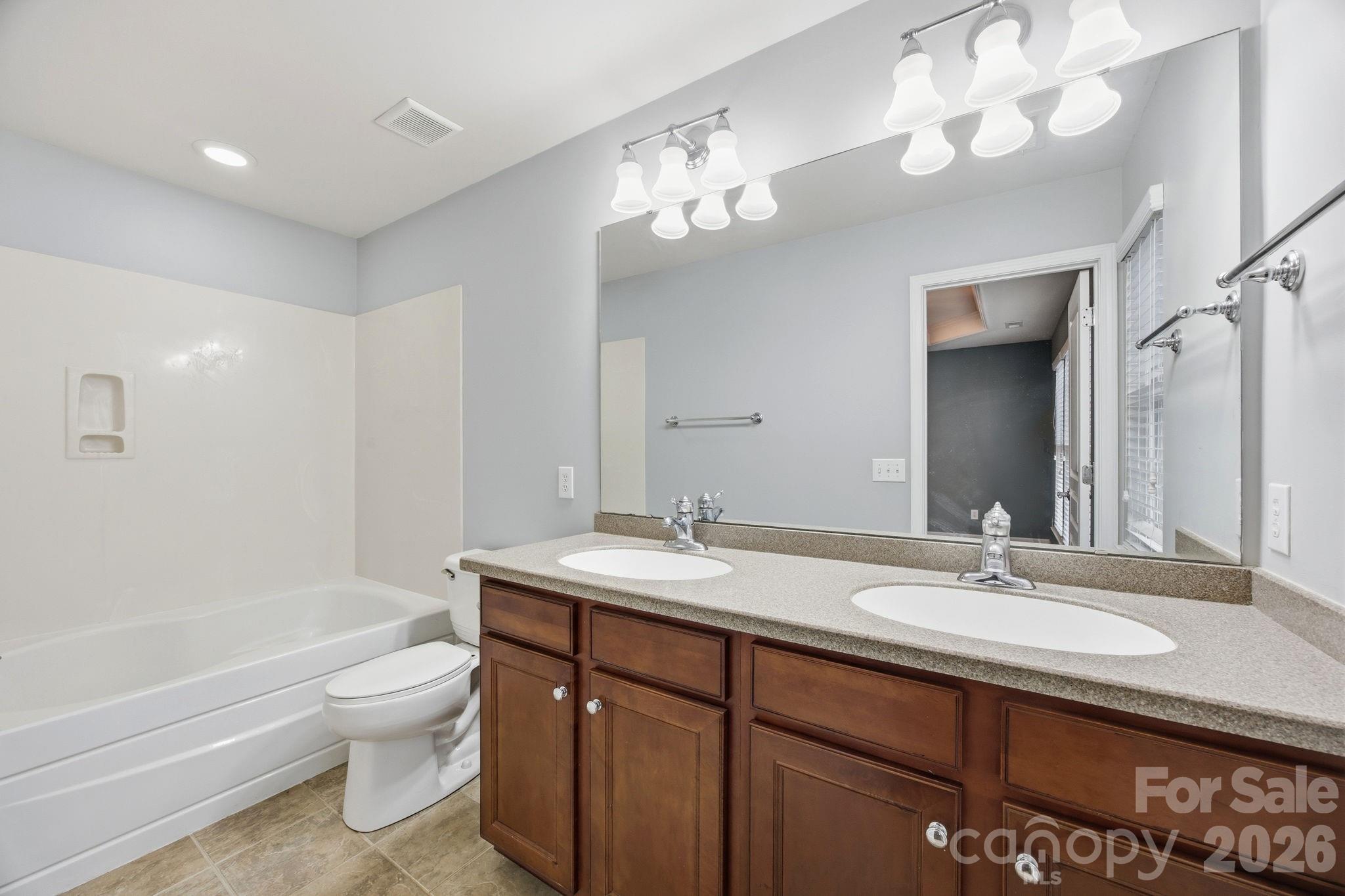 645 6th Baxter Crossing Fort Mill, SC 29708 - Photo 14 of 32 a bathroom with a sink a toilet and a mirror