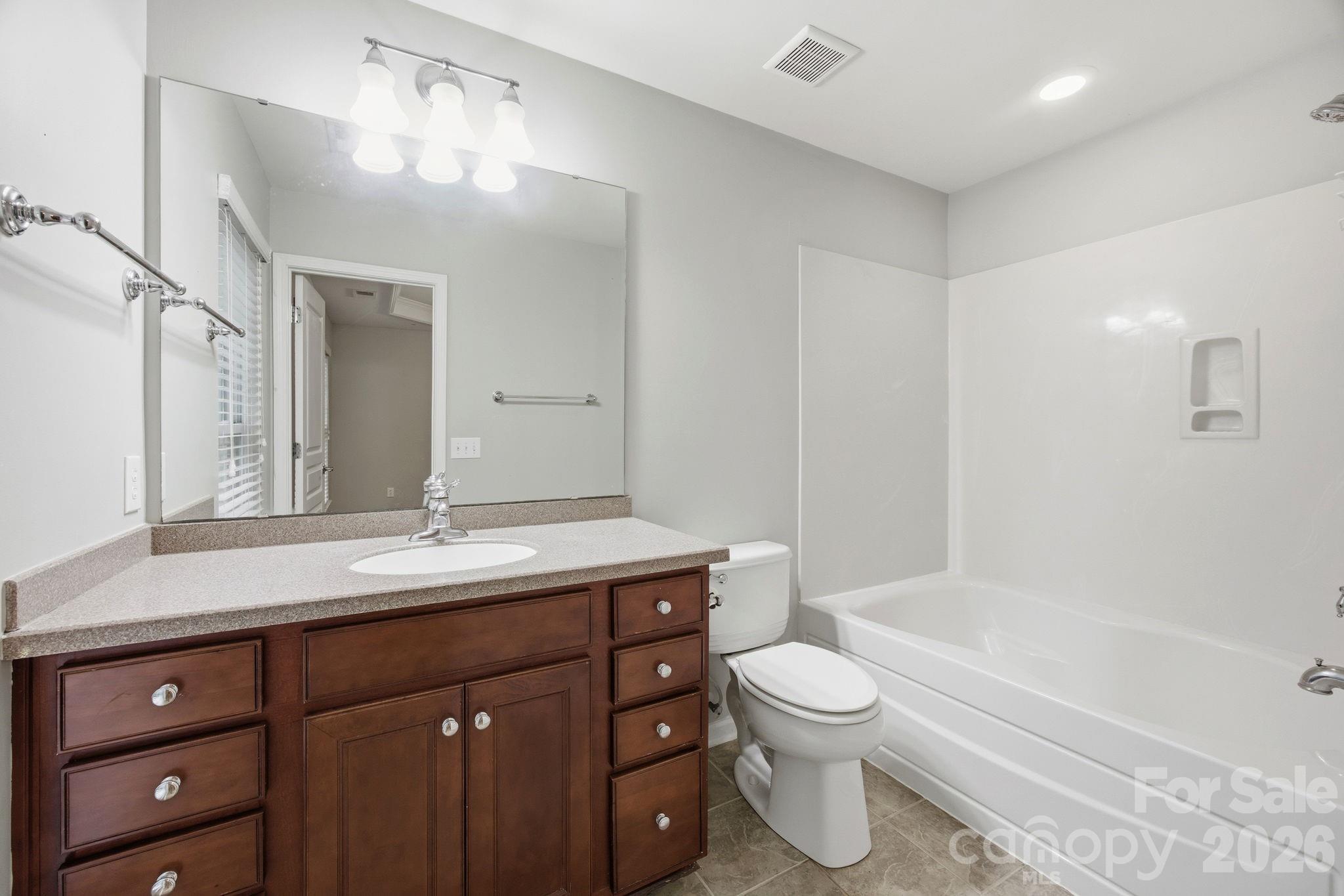 645 6th Baxter Crossing Fort Mill, SC 29708 - Photo 17 of 32 a bathroom with a granite countertop sink a toilet and a bathtub