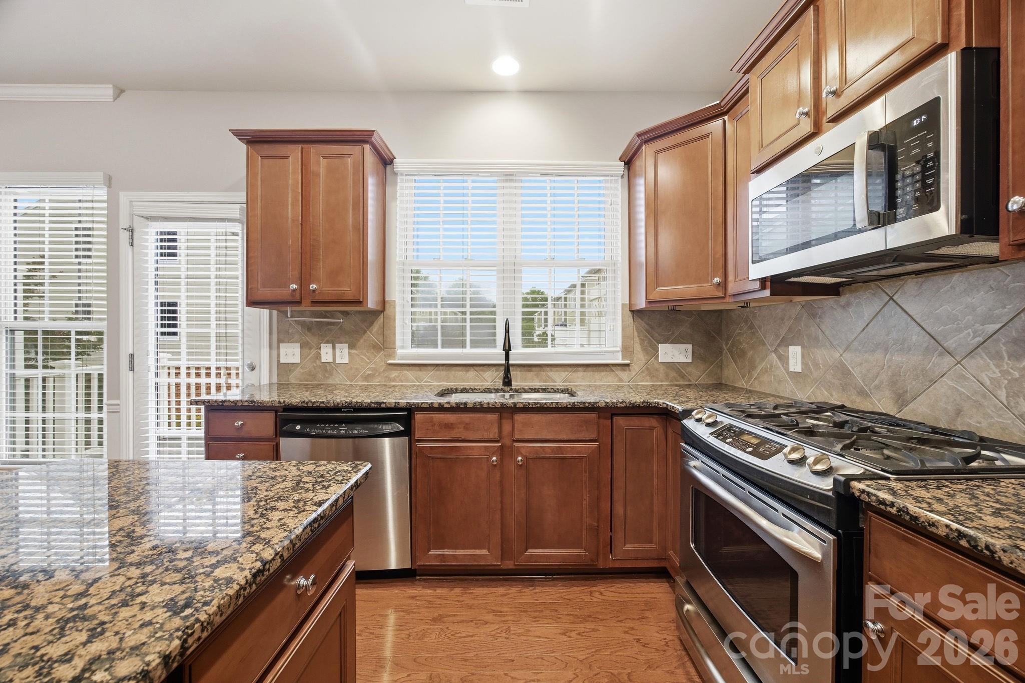 645 6th Baxter Crossing Fort Mill, SC 29708 - Photo 5 of 32 a kitchen with stainless steel appliances granite countertop a stove a sink and a microwave