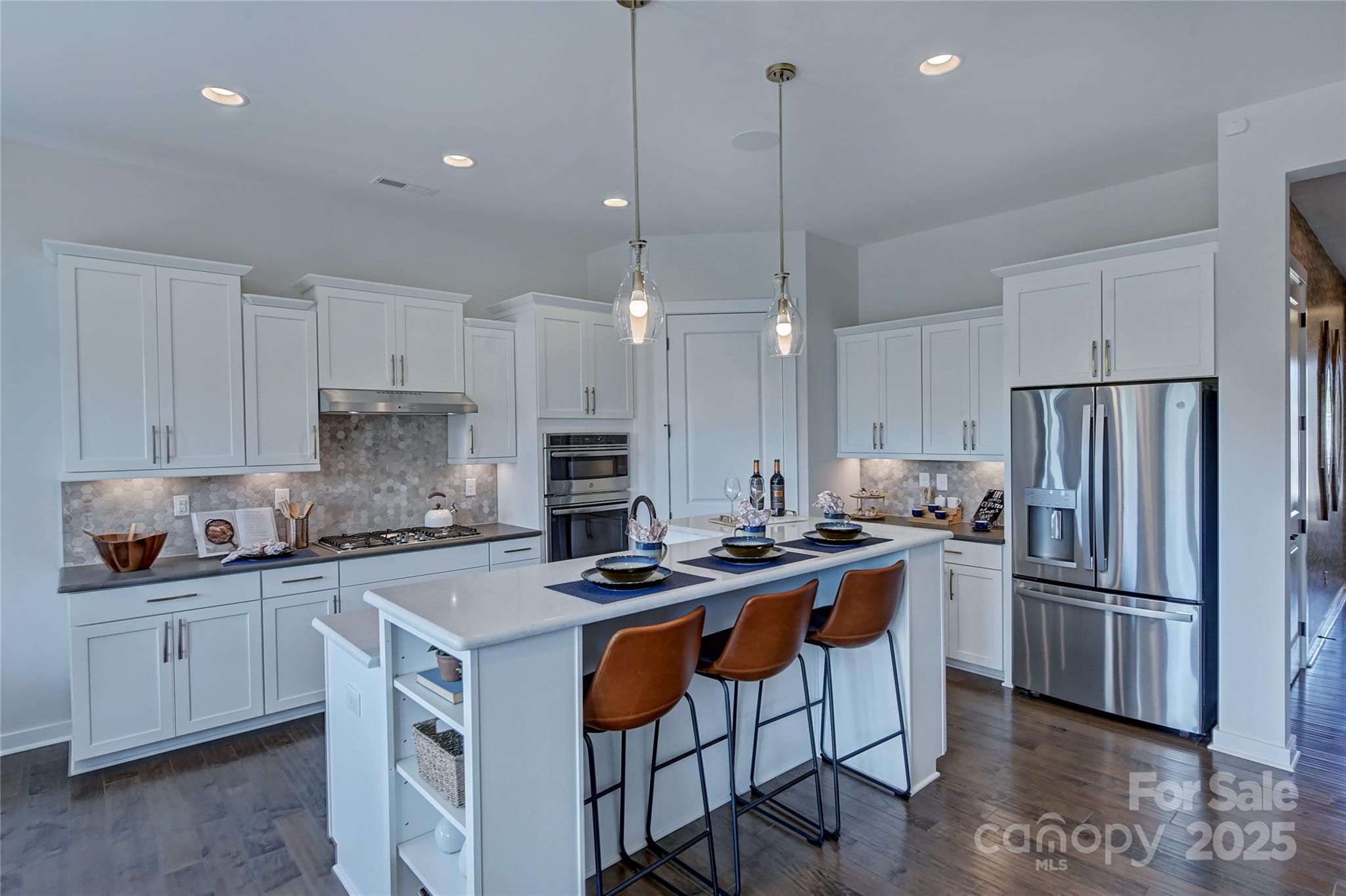 1475 Hubert Graham Way Tega Cay, SC 29708 - Photo 4 of 27 a kitchen with stainless steel appliances a stove a sink a refrigerator and a center island
