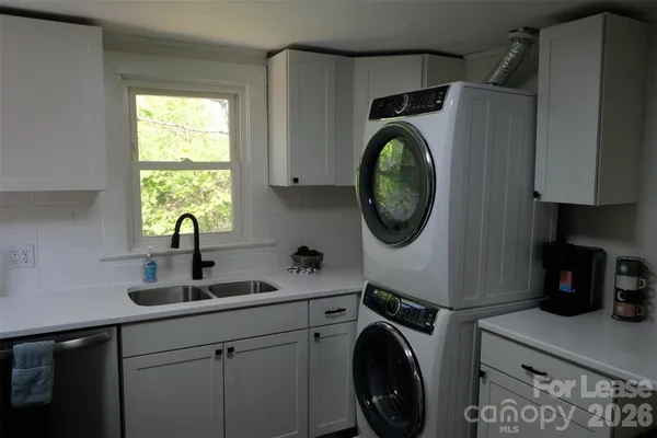 a utility room with sink dryer and washer