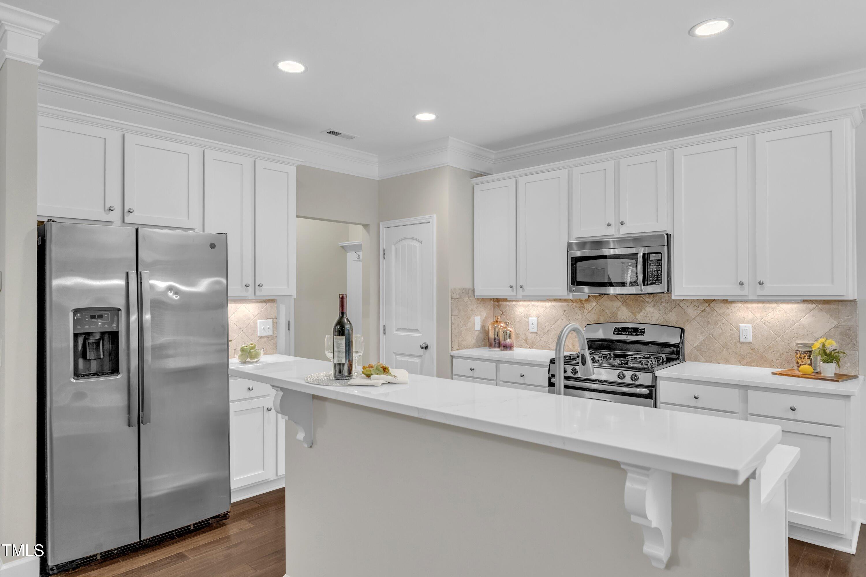 2073 Weston Green Loop Cary, NC 27513 - Photo 14 of 52 a kitchen with stainless steel appliances a refrigerator sink and microwave