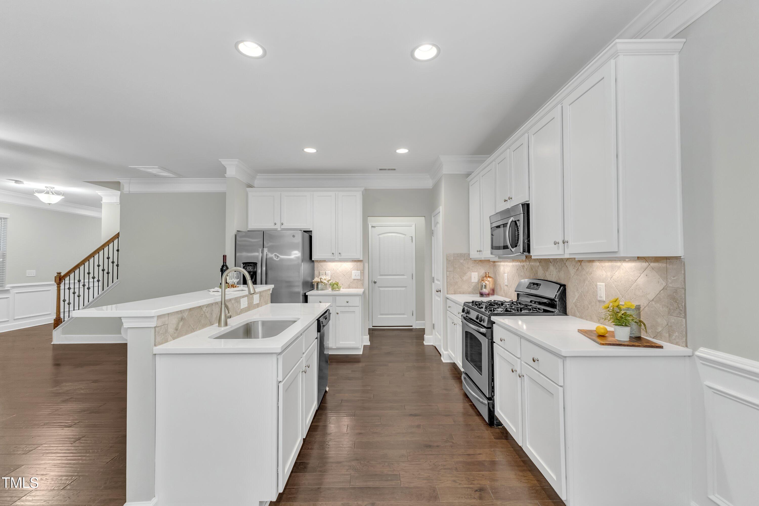 2073 Weston Green Loop Cary, NC 27513 - Photo 16 of 52 a kitchen with white cabinets stove and sink