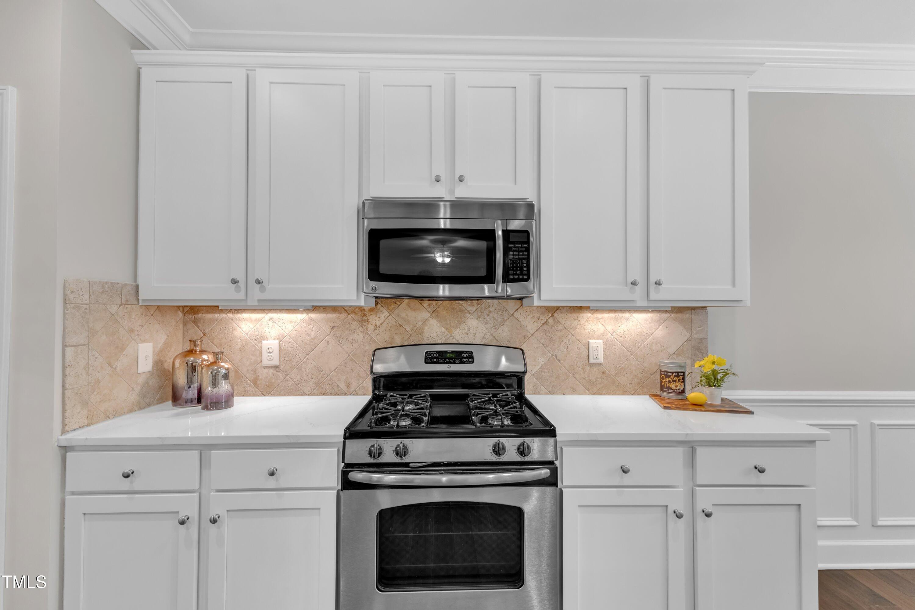 2073 Weston Green Loop Cary, NC 27513 - Photo 19 of 52 a kitchen with white cabinets and appliances