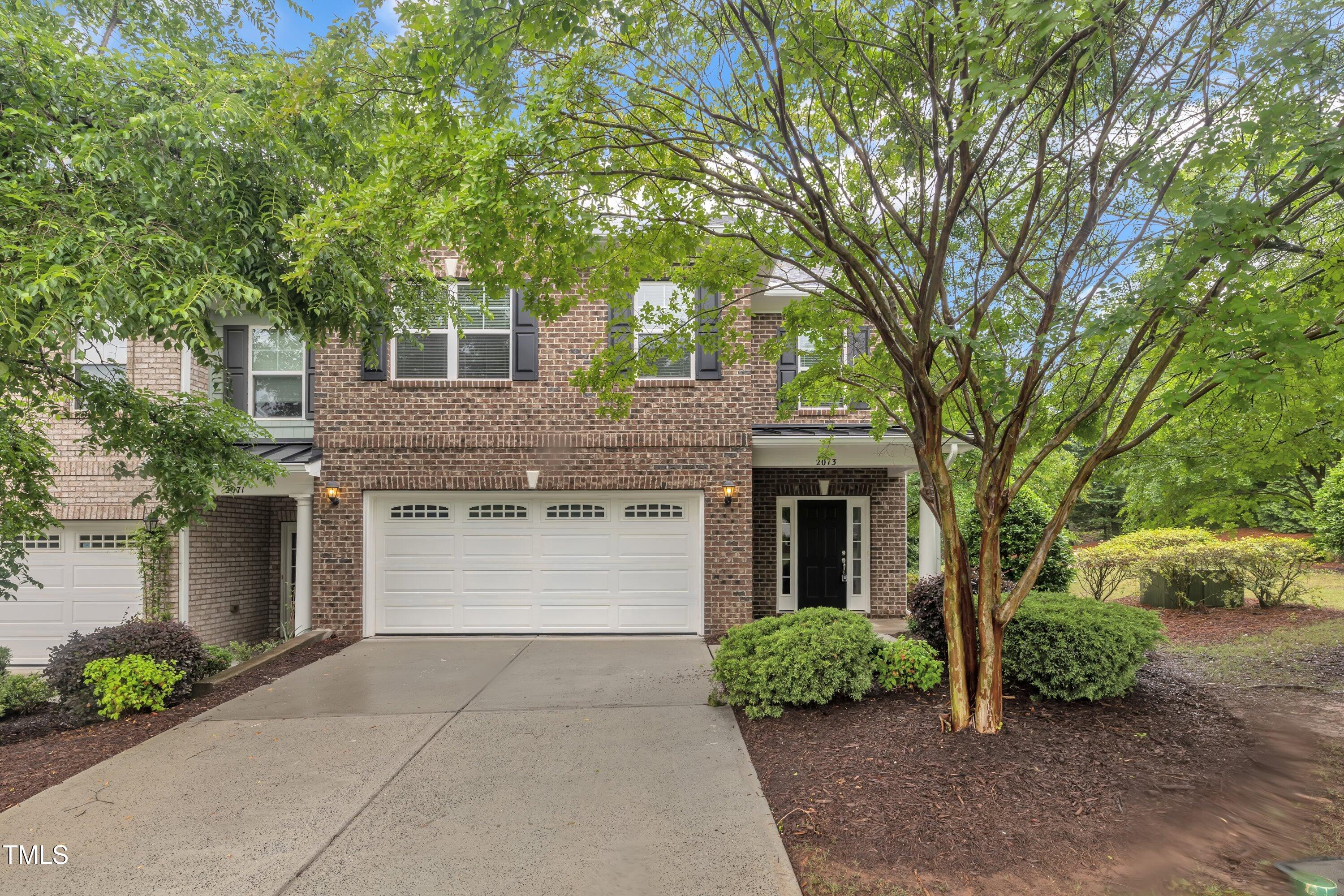 2073 Weston Green Loop Cary, NC 27513 - Photo 3 of 52 a front view of a house with garden