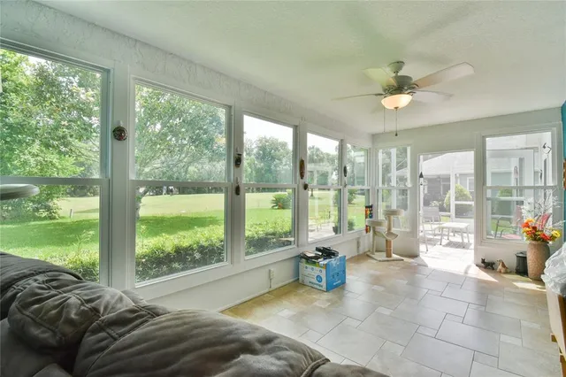 a bed sitting in a bedroom next to a large window with garden view