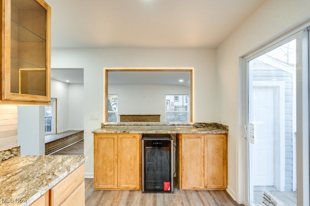 3720 Baird Road Stow, OH 44224 - Photo 13 of 45 Kitchen with wine cooler, light wood-type flooring, light stone counters, and plenty of natural light