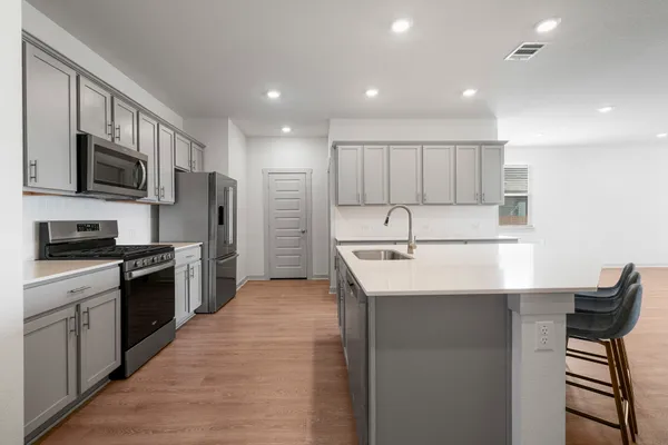 a kitchen with stainless steel appliances granite countertop a refrigerator and a stove