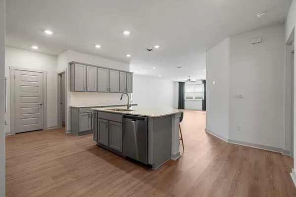 a kitchen with stainless steel appliances granite countertop a sink a stove and a wooden floors