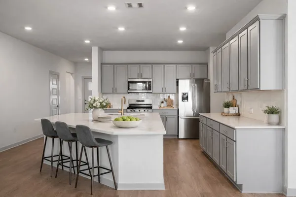 a kitchen with refrigerator and chairs