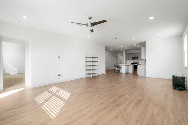 a view of empty room with wooden floor and window