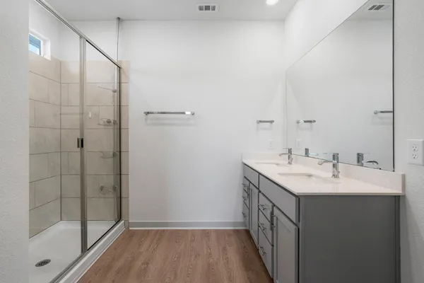 a bathroom with a double vanity sink and a mirror
