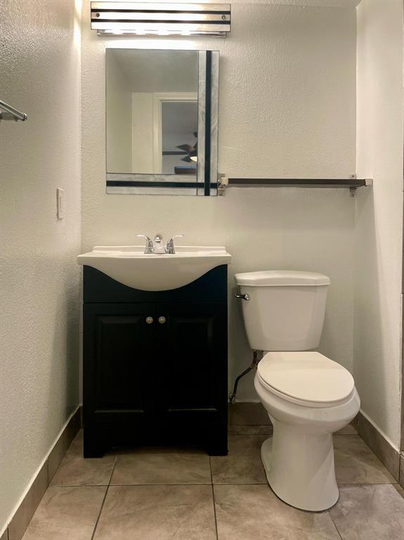 307 East Mitchell Street, Unit F Arlington, TX 76010 - Photo 4 of 15 a bathroom with a toilet sink and mirror