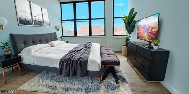 a bedroom with a bed window and flat screen tv