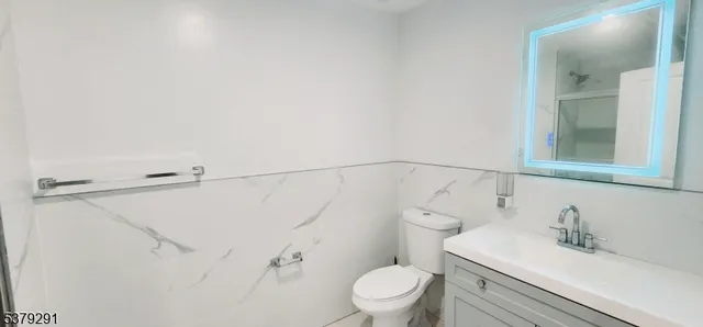 a bathroom with a sink vanity mirror and toilet
