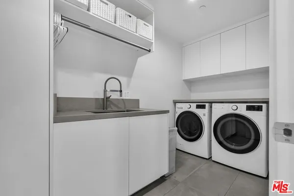 a utility room with sink dryer and washer