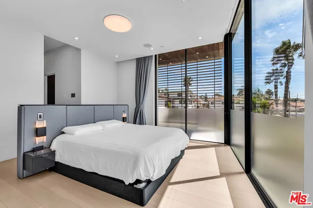 a bedroom with a large bed and a chandelier