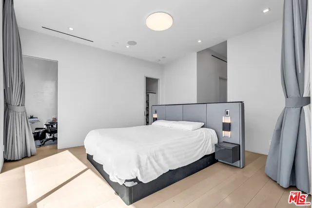 a bedroom with a bed and a large mirror