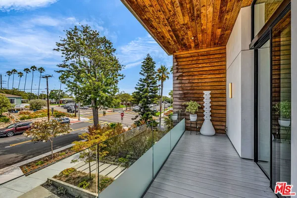 a view of a balcony with wooden floor and iron stairs