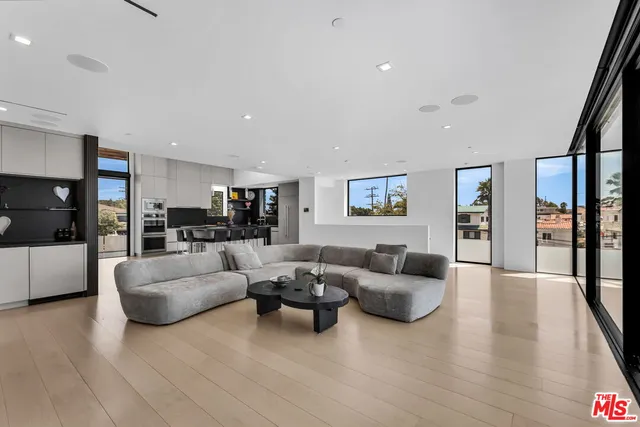 a living room with furniture and hard wood flooring