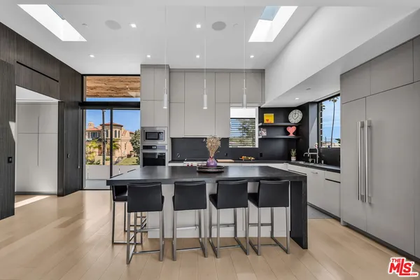 a kitchen with stainless steel appliances kitchen island granite countertop a refrigerator and a stove top oven