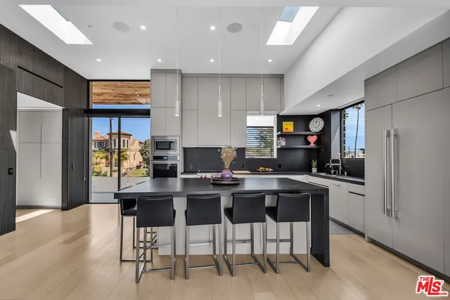 a kitchen with stainless steel appliances kitchen island granite countertop a refrigerator and a stove top oven