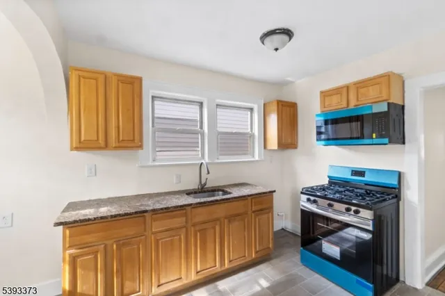a kitchen with stainless steel appliances granite countertop a stove a sink and a microwave