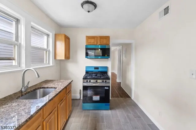 a kitchen with granite countertop a stove and a sink