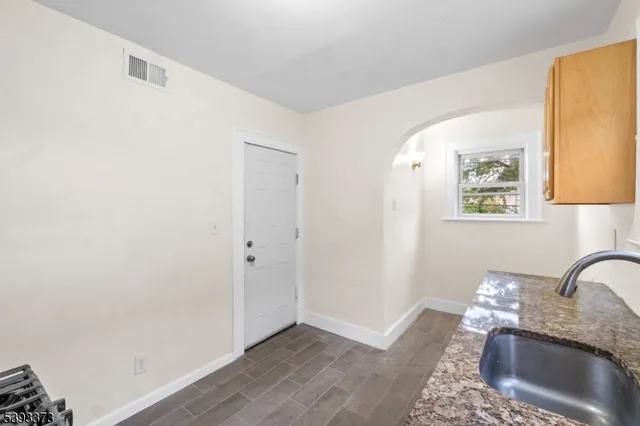 a kitchen with granite countertop white cabinets and window