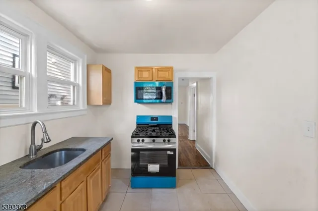 a kitchen with stainless steel appliances a stove a sink and a microwave