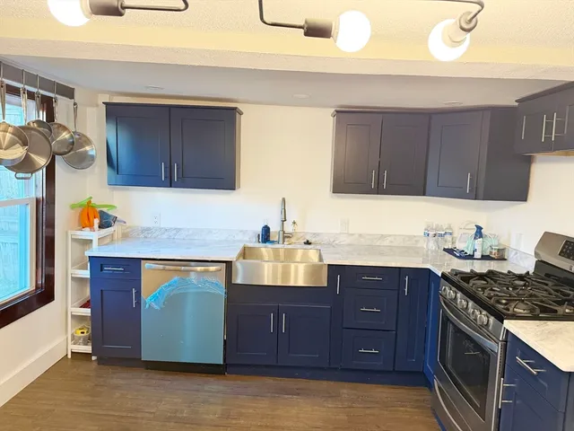 a kitchen with stainless steel appliances granite countertop wooden cabinets a stove a sink and dishwasher