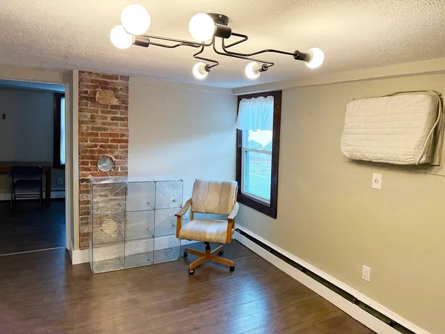a view of a room with gym equipment and wooden floor