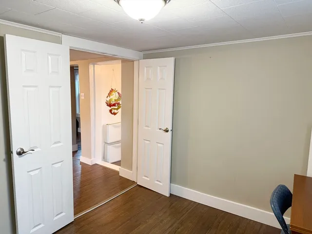 an empty room with wooden floor and entrance