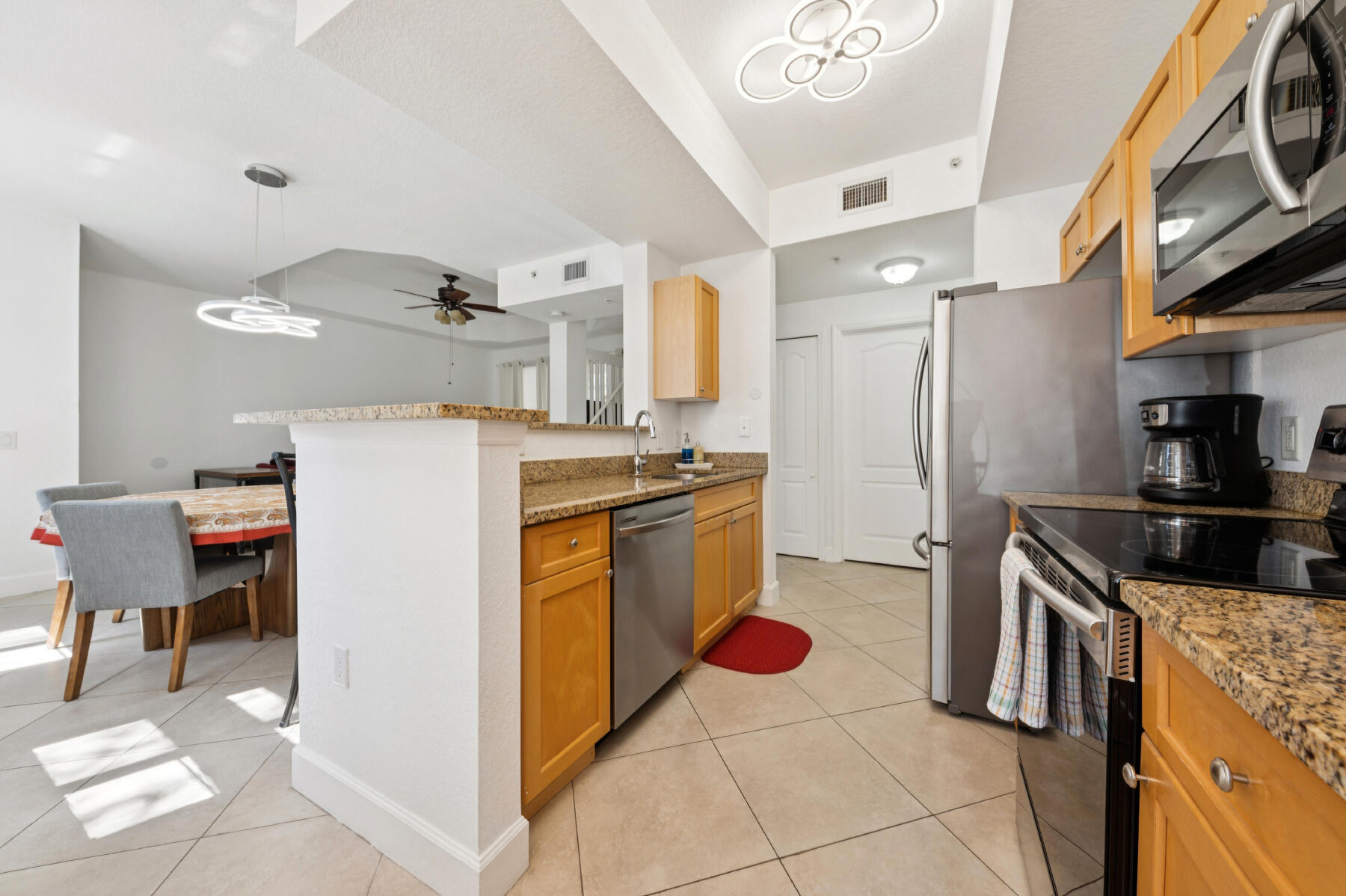 11022 Legacy Drive, Unit 101 Palm Beach Gardens, FL 33410 - Photo 5 of 16 a kitchen with a refrigerator a stove top oven and a sink