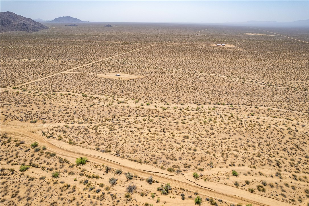 0 East Arroyo Road Yucca, AZ 86438 - Photo 6 of 25 Expansive desert landscape with scattered vegetation, featuring distant mountains and visible roads traversing the terrain