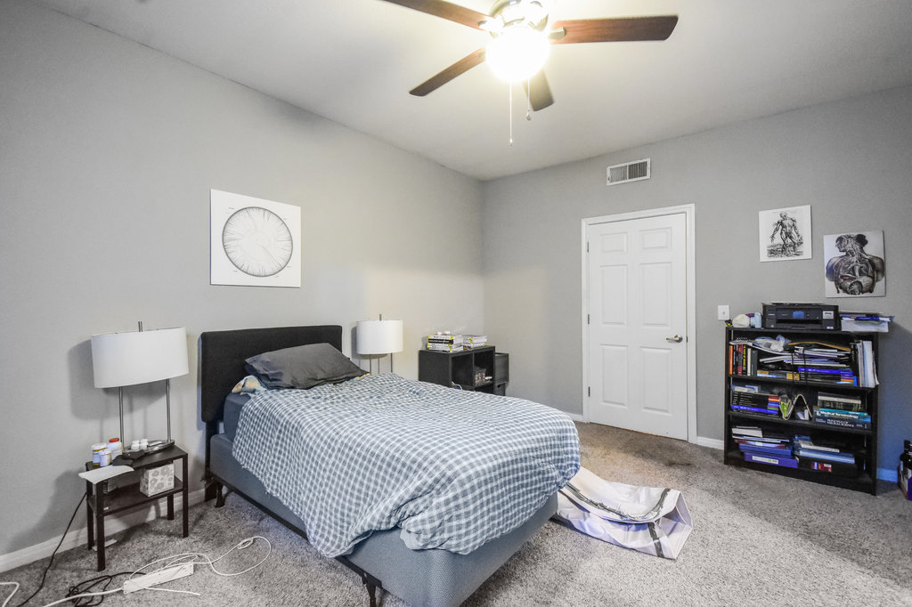 2502 Leon Street, Unit 100 Austin, TX 78705 - Photo 11 of 17 a bedroom with a bed and a chandelier