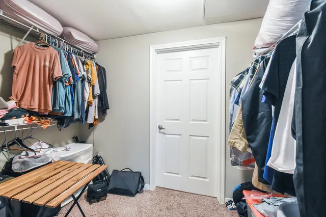 a view of walk in closet with clothes and shoes
