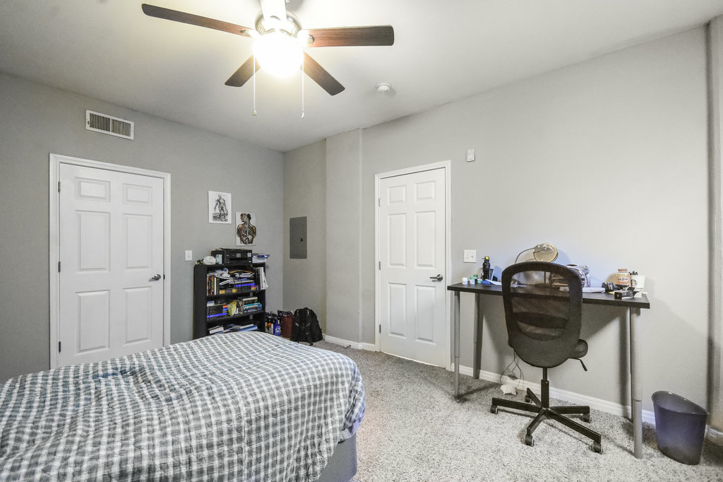 2502 Leon Street, Unit 100 Austin, TX 78705 - Photo 14 of 17 a bedroom with a bed and a chandelier