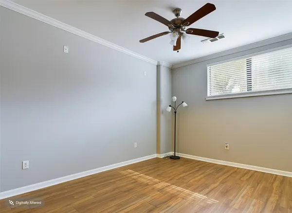a view of a big room with wooden floor and a ceiling fan