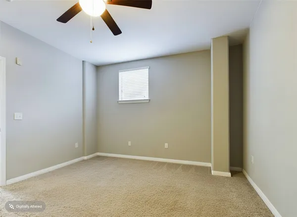 an empty room with ceiling fan and window