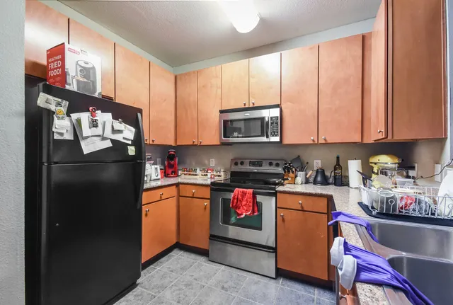 a kitchen with stainless steel appliances granite countertop a refrigerator stove and sink