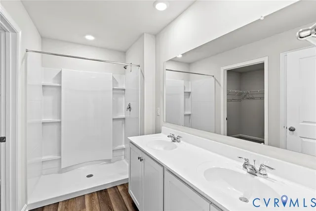 a bathroom with a sink shower and a mirror