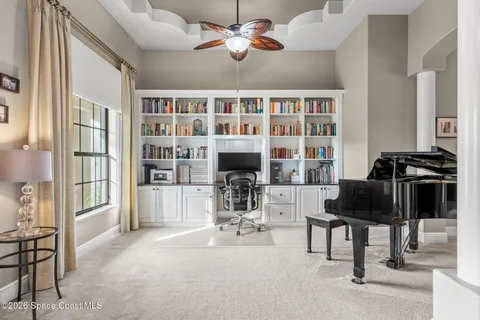 a view of a dining room and livingroom with furniture large window a rug and a chandelier