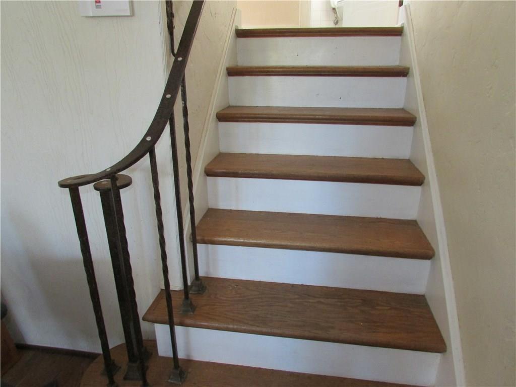 Stairs with wrought iron railing lead to bedrooms.