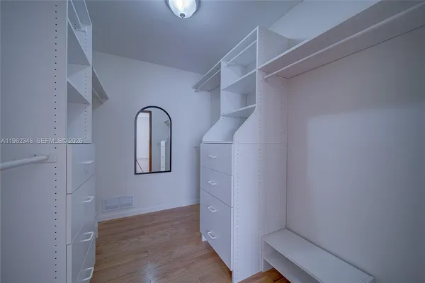a view of closet with wooden floor