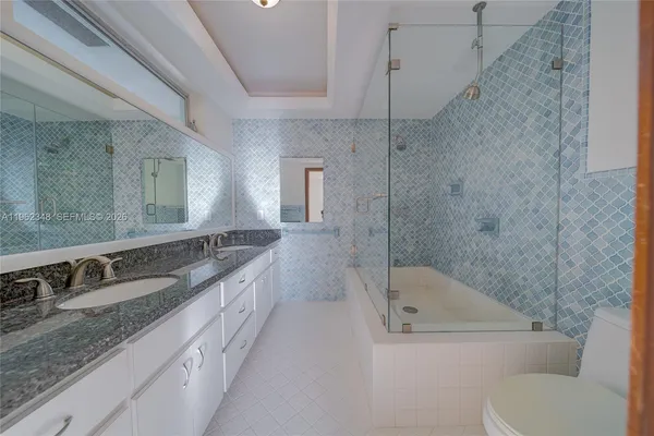 a bathroom with a granite countertop sink toilet and shower