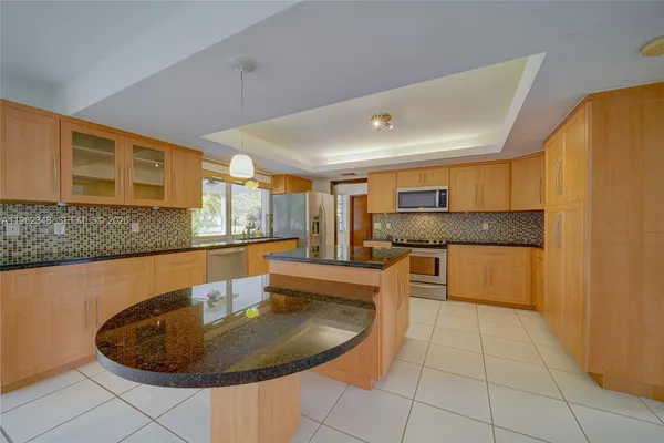 a kitchen with a sink a microwave and cabinets