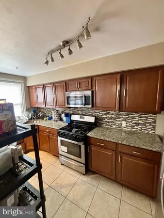 a kitchen with stainless steel appliances granite countertop a stove sink and cabinets