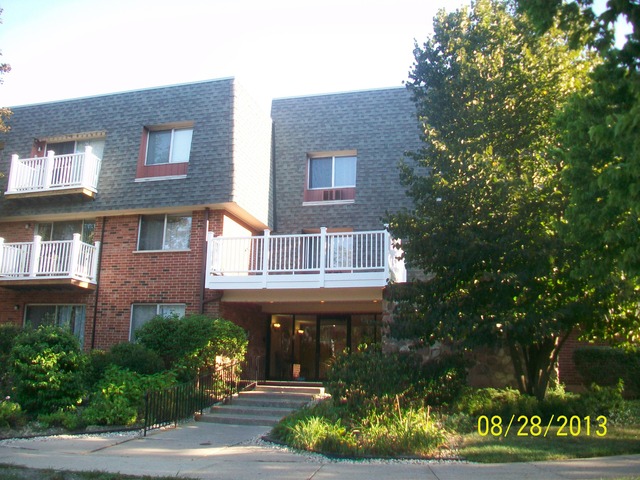 904 Ridge Square, Unit 110 Elk Grove Village, IL 60007 - Photo 1 of 10 a front view of a house with a garden